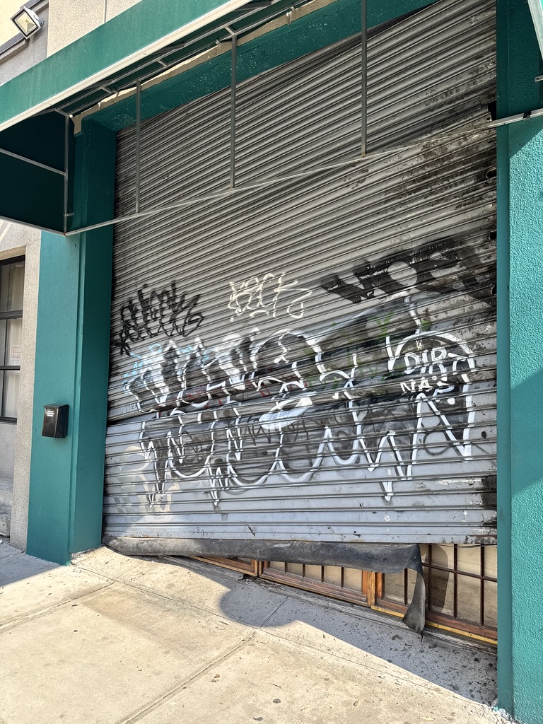 The old Fresh Pops metal gate broken and partly off its track before replacement.