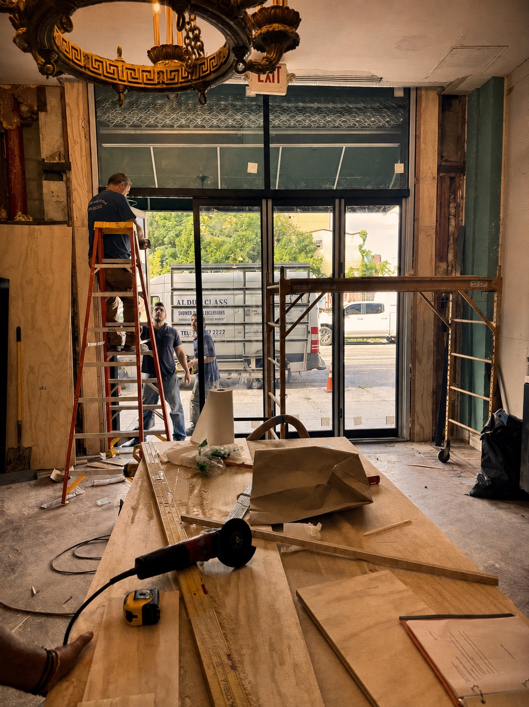 Looking toward the new front doors from inside Fresh Pops, with the chandelier overhead and construction still underway.