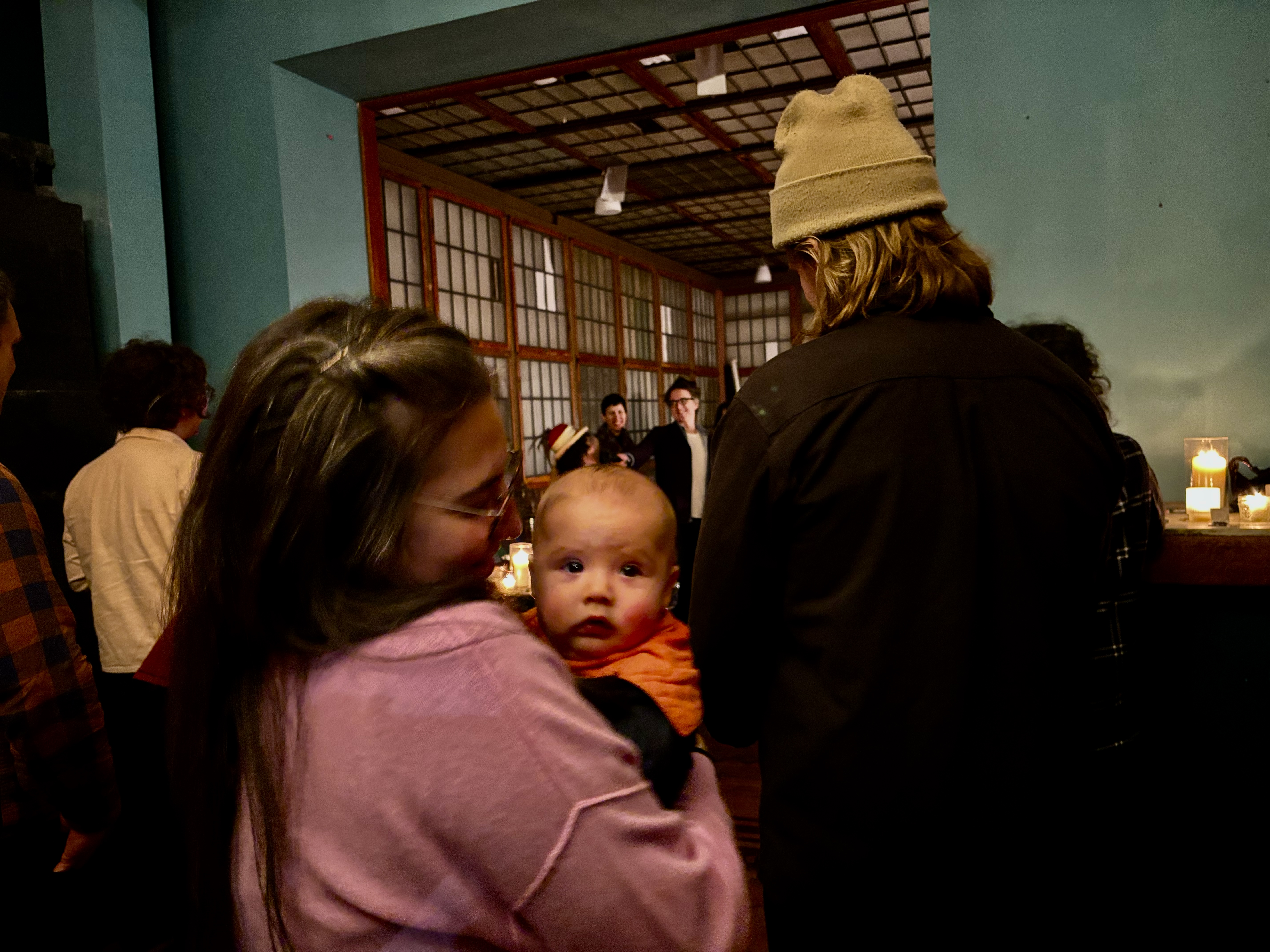 Guests filling the room before construction, including a baby looking straight at the camera.