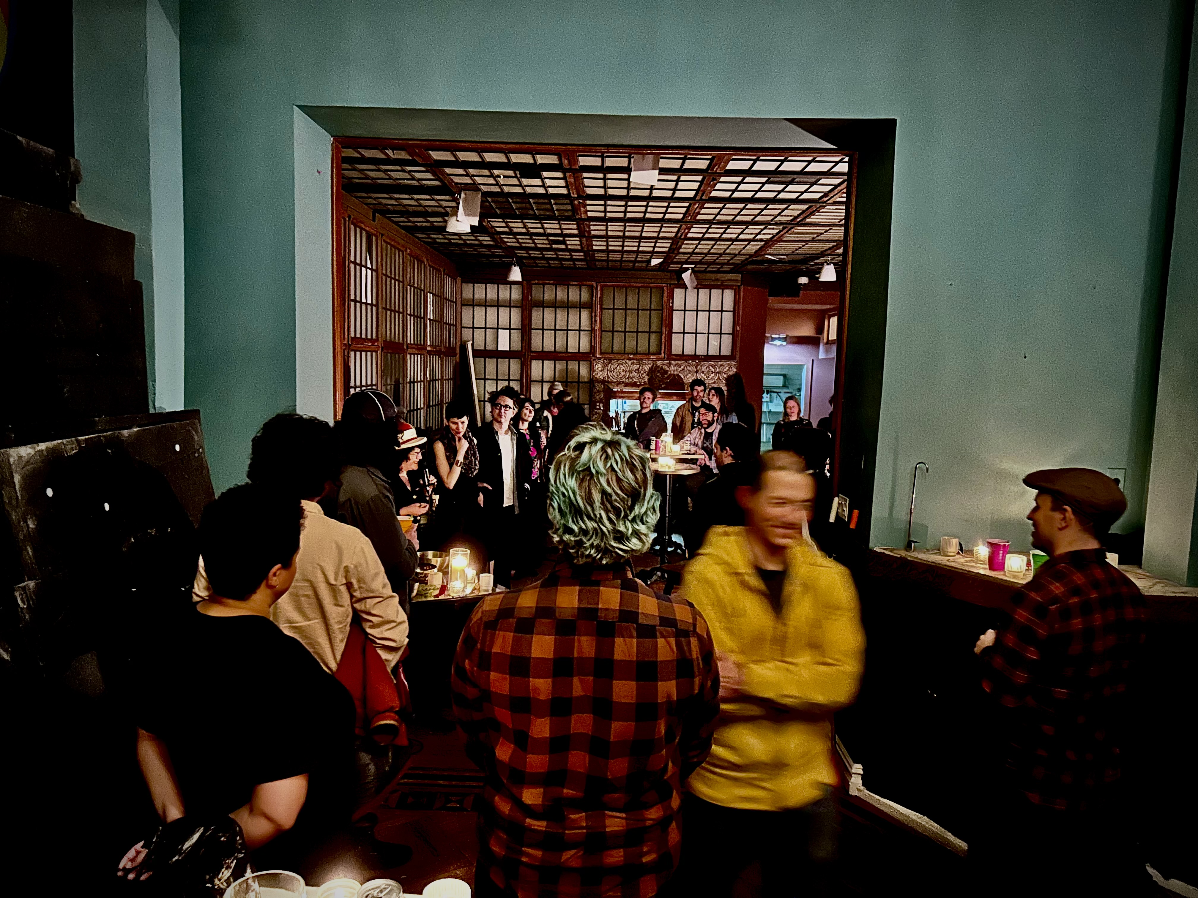 A crowd watching through the doorway into the main room.